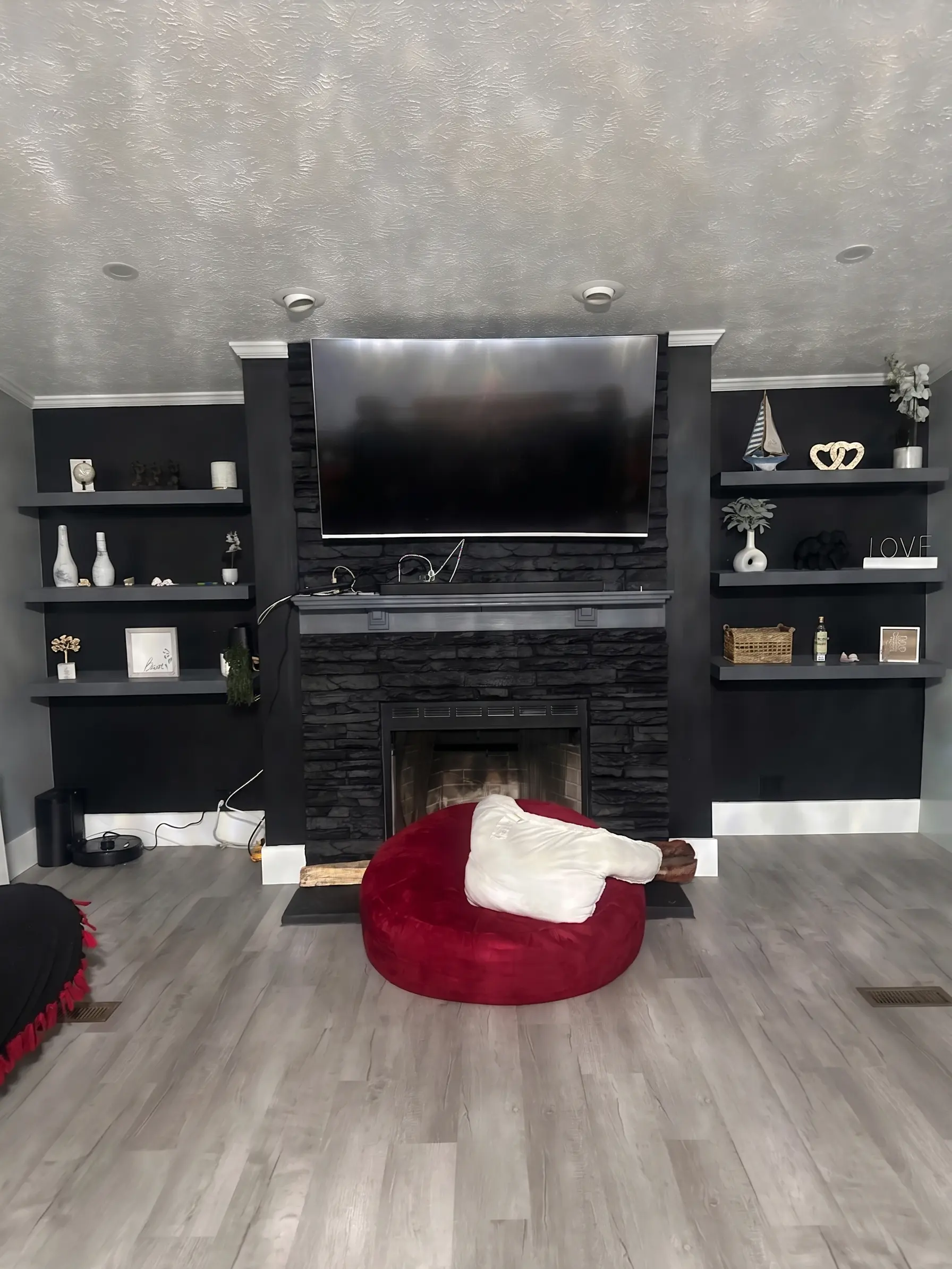 Living room fireplace with built-in TV and shelves by Complete Handy Solutions